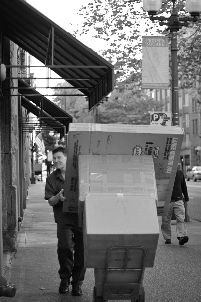 Managing The Packages On The Street.  A UPS Employee At Work.   by seattle