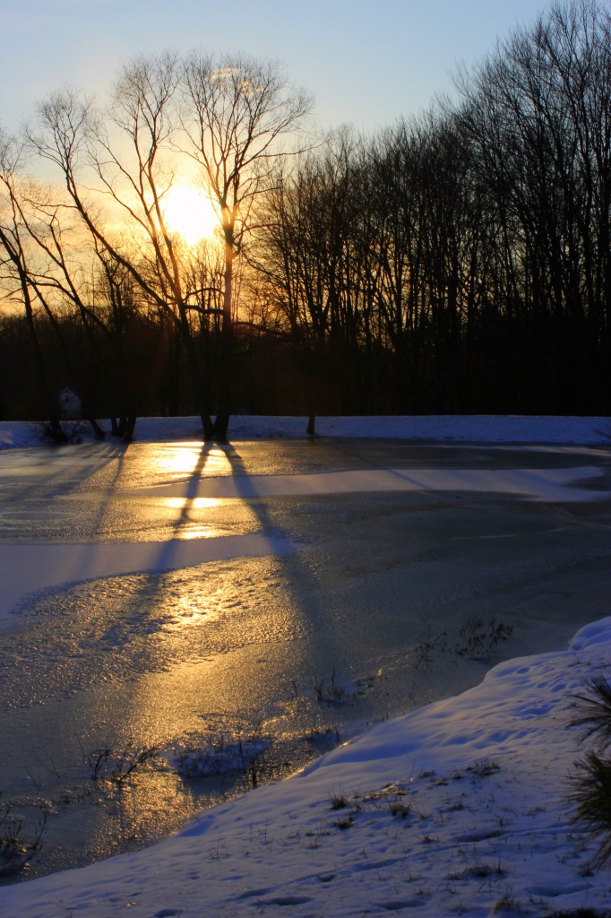 Sunset over frozen pond by skipt07