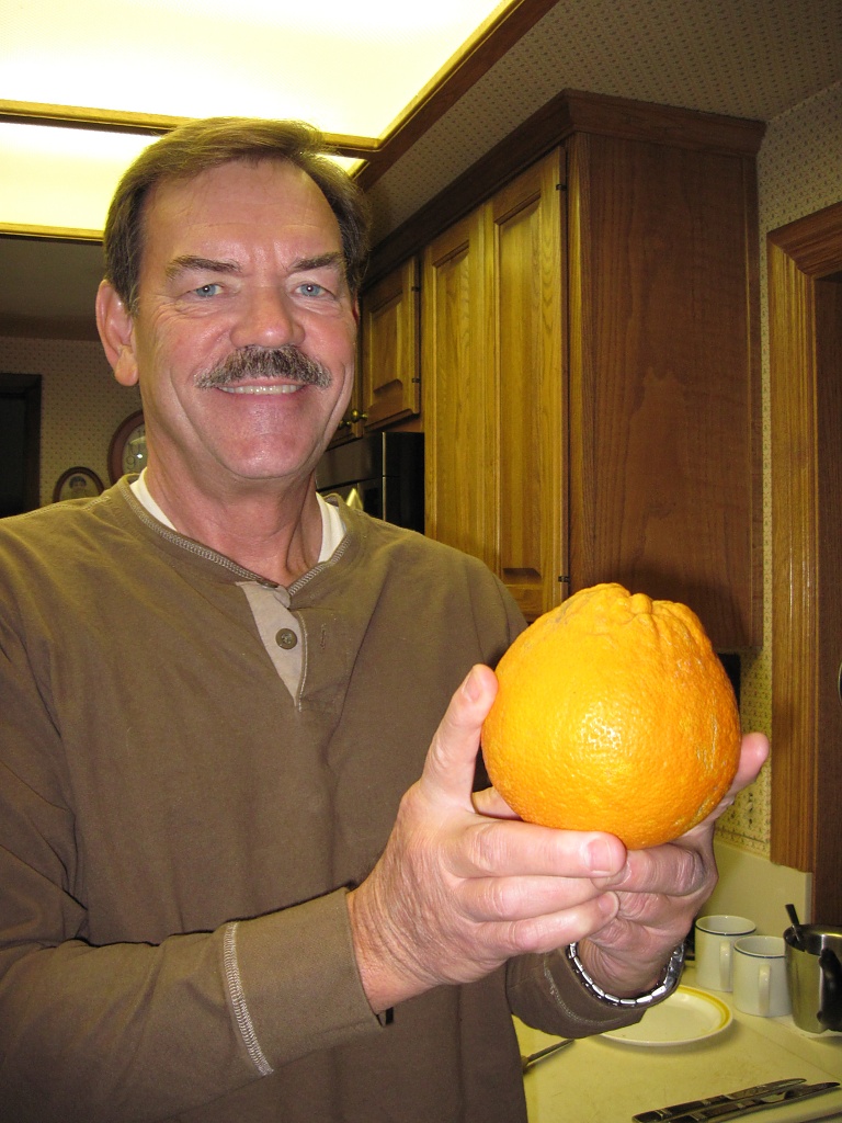 Ken with a Navel Orange from our Tree by Weezilou