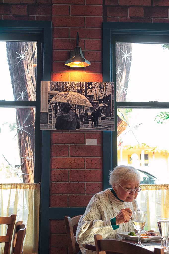A Customer At Fins Bistro Sitting Under One Of My Photographs On Display! by seattle