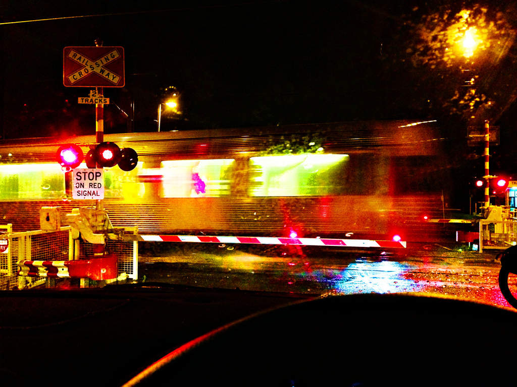 railway crossing on a dark, rainy night by corymbia