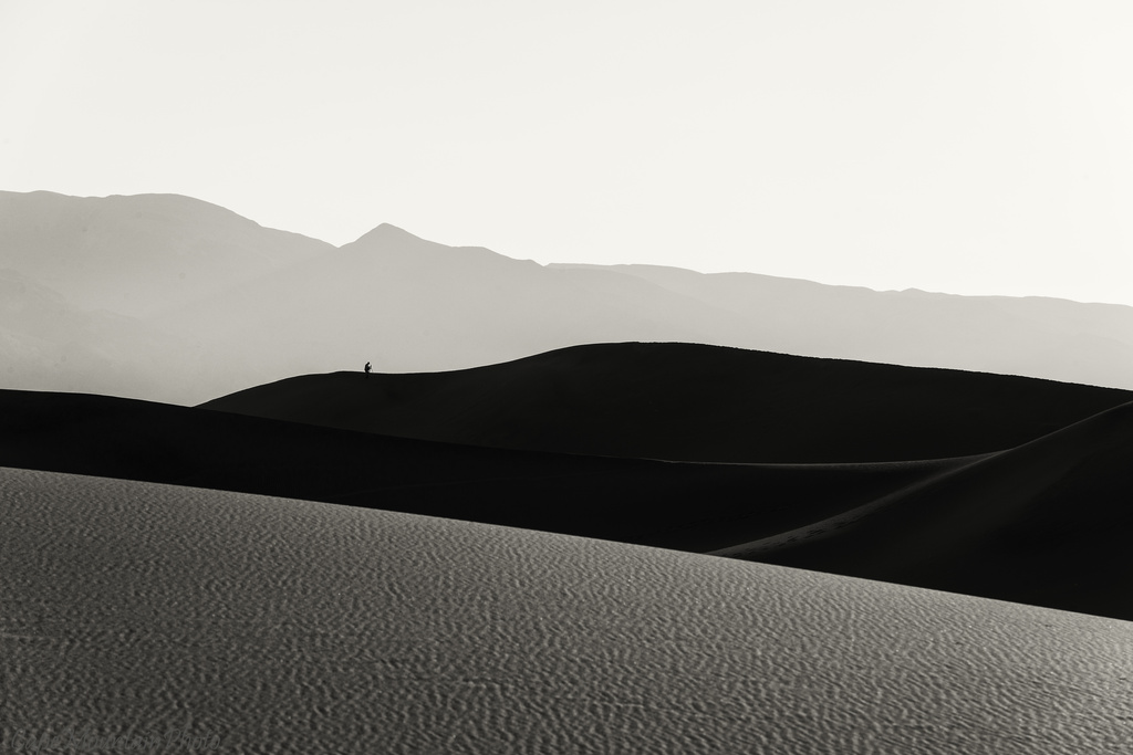 Hiker Enjoying the Dawn Light in the Dunes black and White by jgpittenger