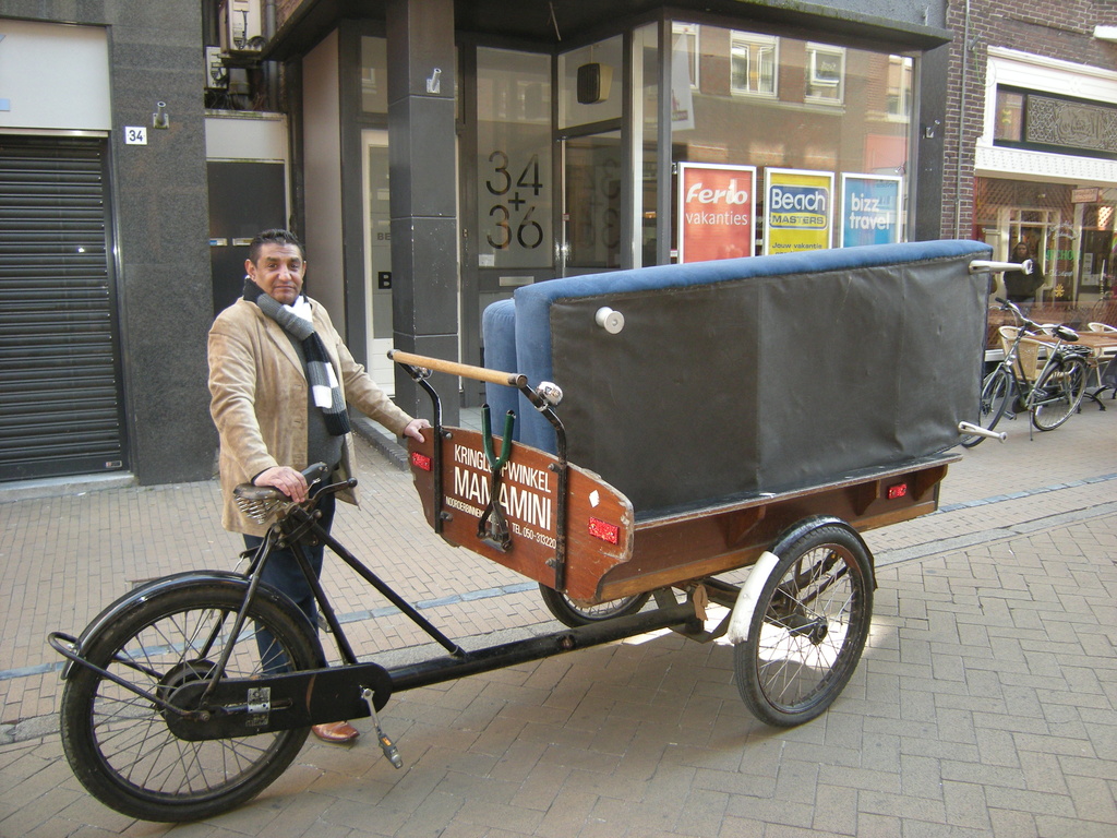 A man with a `` Bakfiets`` moving funiture by pyrrhula