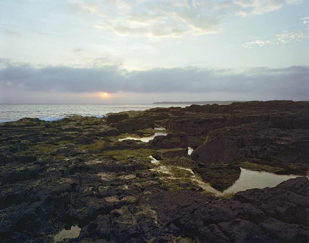 Sun appearing between clouds by peterdegraaff