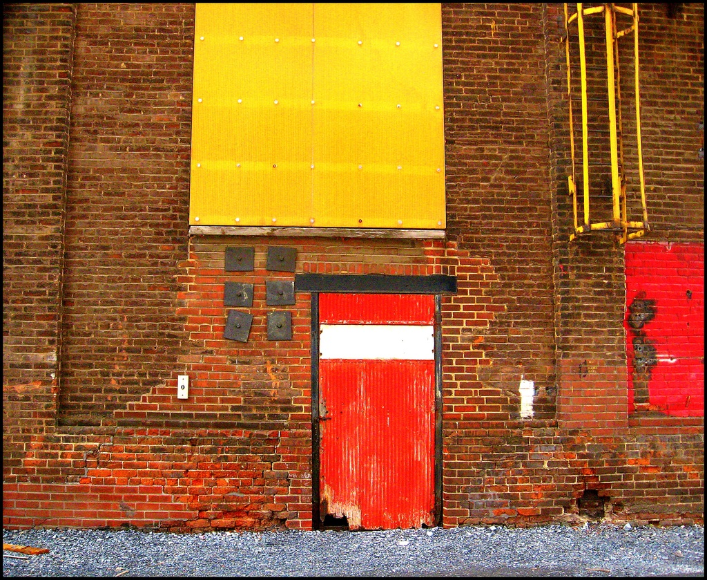 Red, Yellow and Black on Brick by olivetreeann