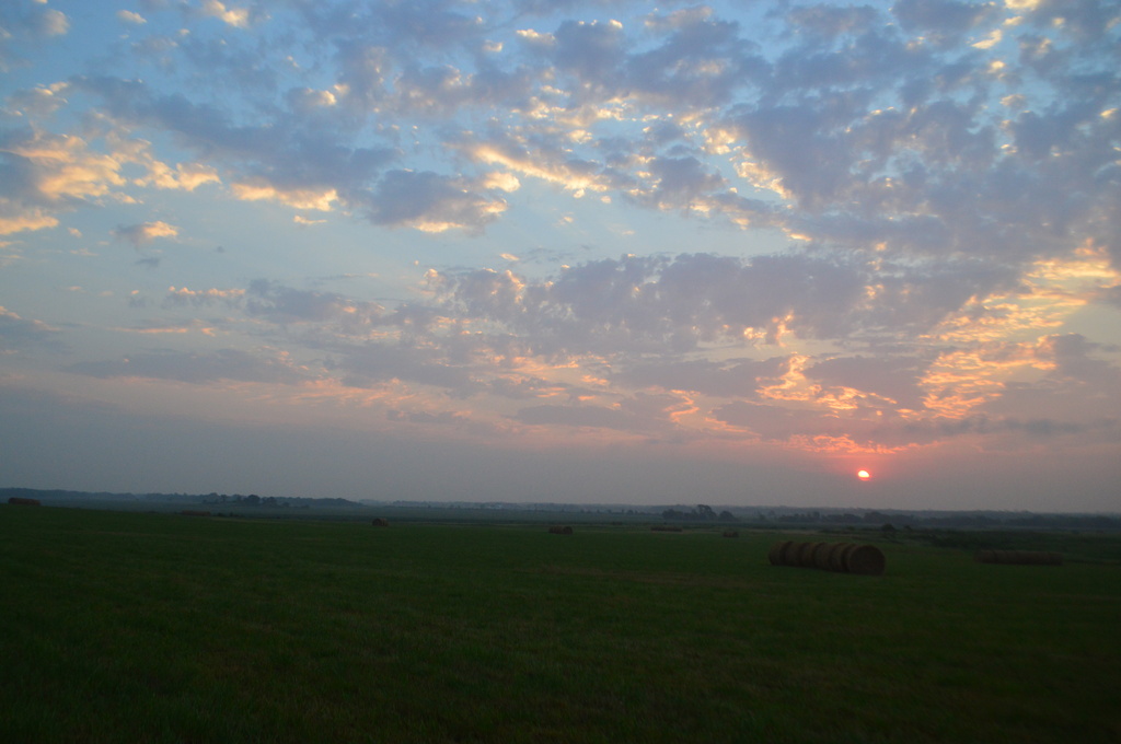 Kansas Sunrise Over Field of Haybales by kareenking