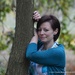 Woman leaning on a tree by motorsports