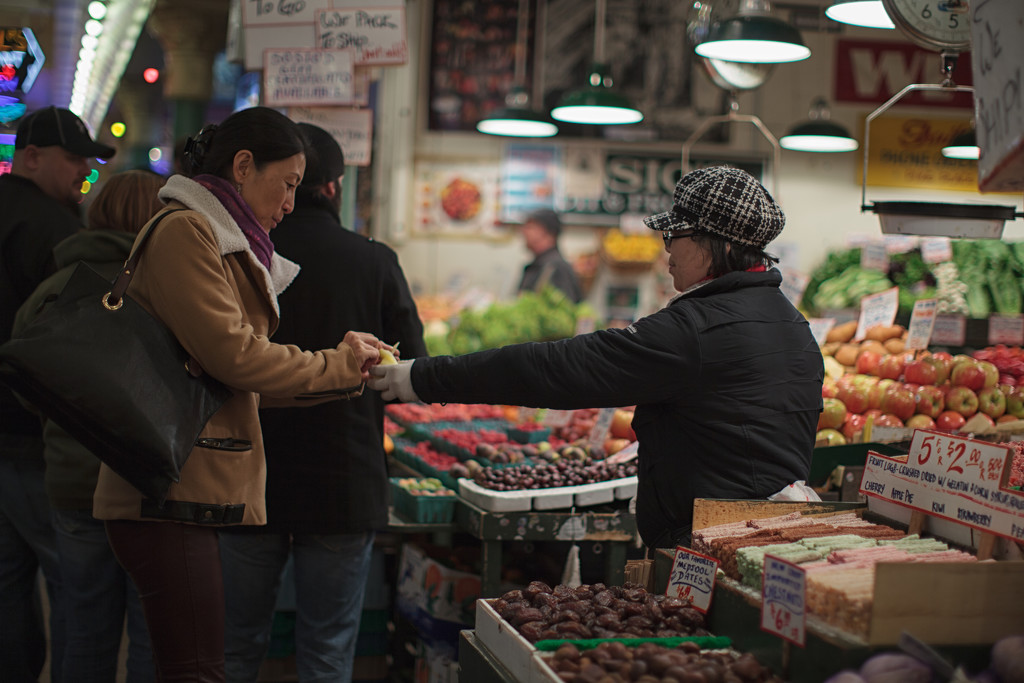 Sampling A Piece Of Fresh Fruit At The Market. by seattle