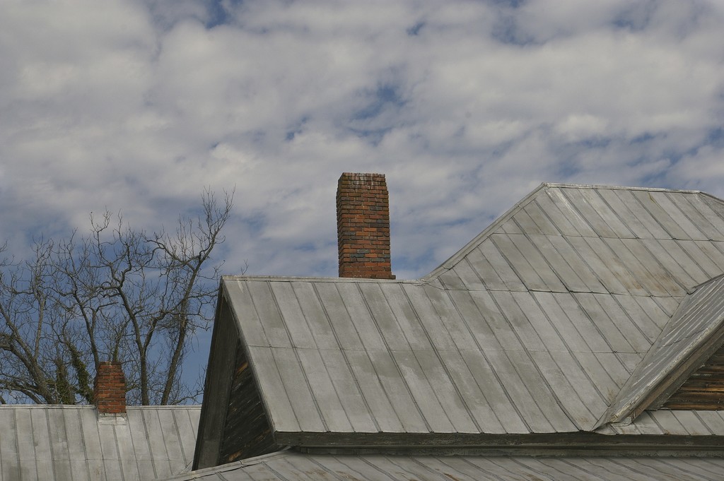 Roof angles and chimney against a cloudy sky! by thewatersphotos