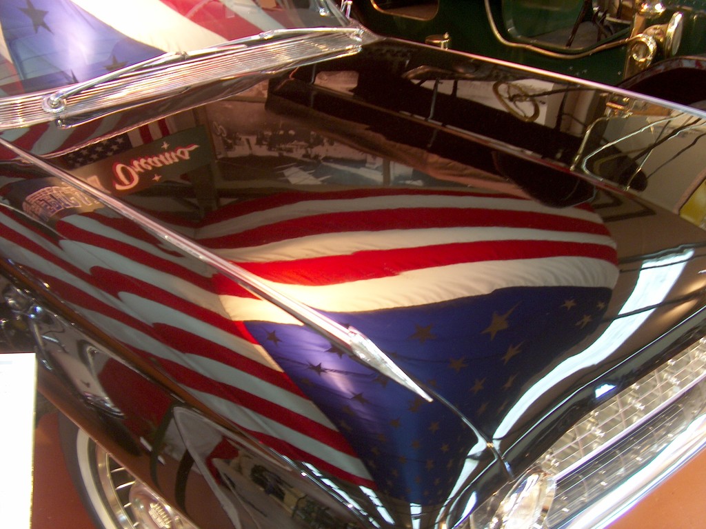 Reflection of a flag on a cars body. by sdutoit