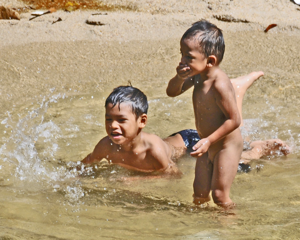 Children enjoying rainforest stream by ianjb21