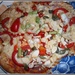 A homemade pizza with peppers and seeds. by grace55
