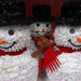 Smiling snowmen with red scarves by mittens