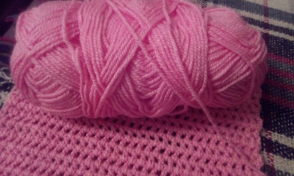 A pink crocheted scarf in progress by grace55
