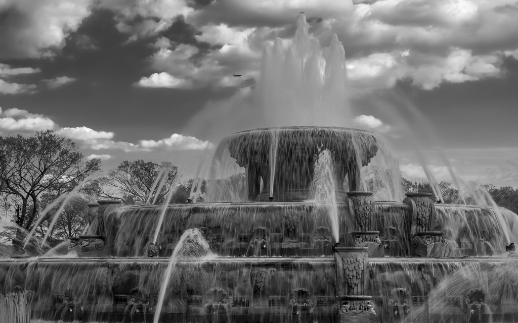 Clouds and an Airplane Over Buckingham Fountain  by taffy