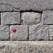 Tiny red heart on cobbled street.  by cocobella