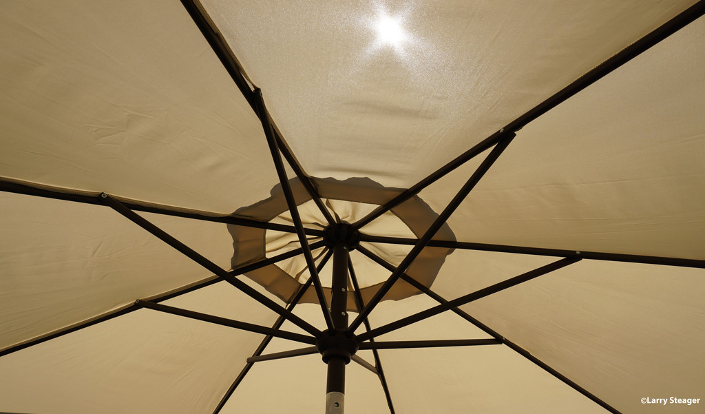 Sun through a umbrella by larrysphotos