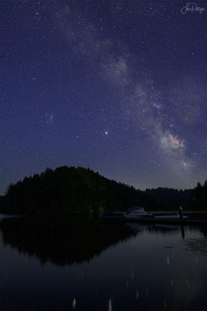 Boats Resting Under the Milky Way and Meteor Shower by jgpittenger