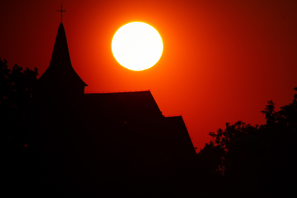 The Sun over a church by j_kamil