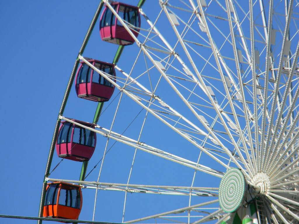 Orange and Purple Cars on Ferris Wheel by sfeldphotos
