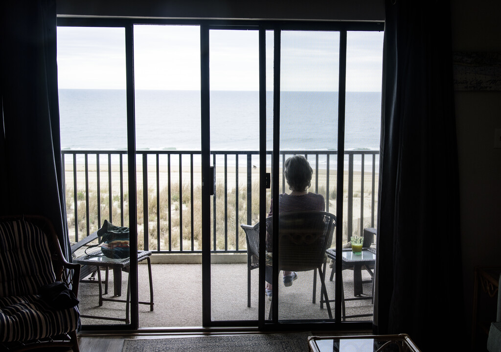 87 year old mother-in-law takes in beach from balcony by ggshearron