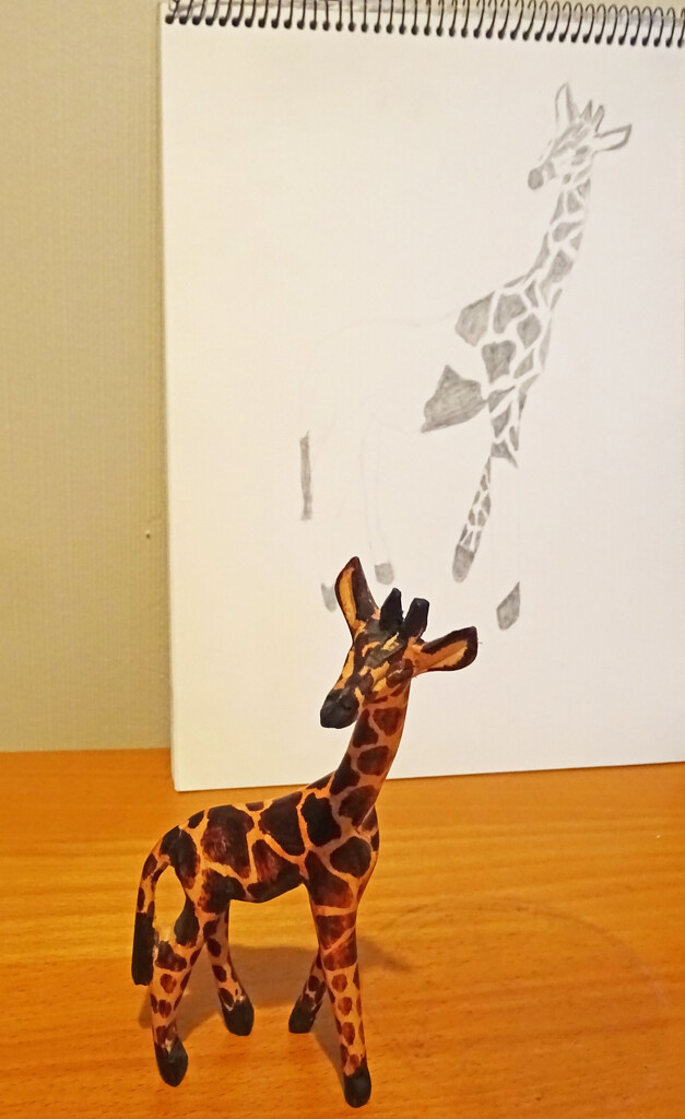 Giraffe emerging from the paper by marianj