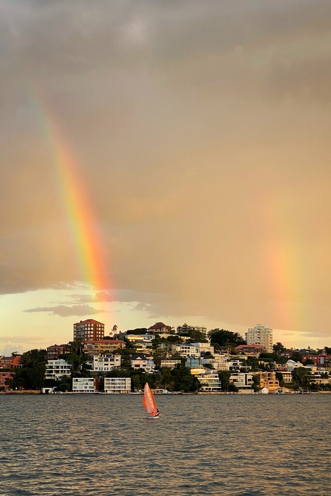 Quick shot of a double rainbow and sailing dinghy on Sydney Harbour. Taken from the ferry at sundown.  by johnfalconer