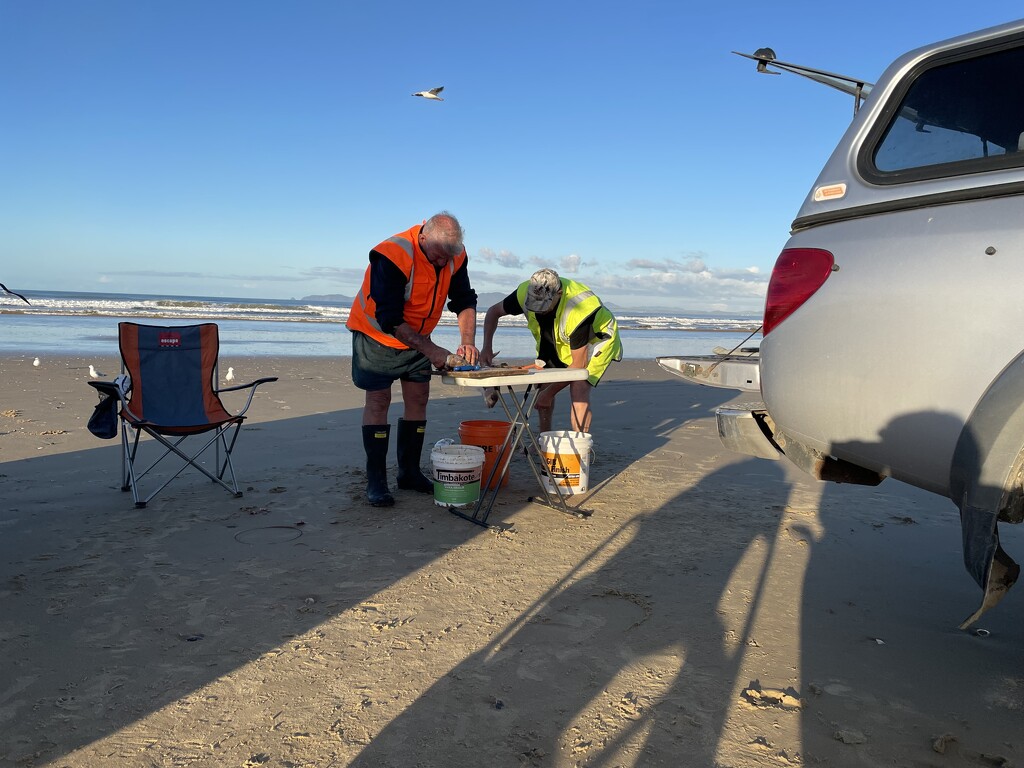 Keith and Neil cleaning fish caught on Saturday  by Dawn