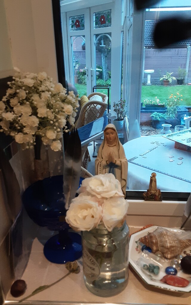 A statue of Mother Mary and vase of white roses from our garden. by grace55