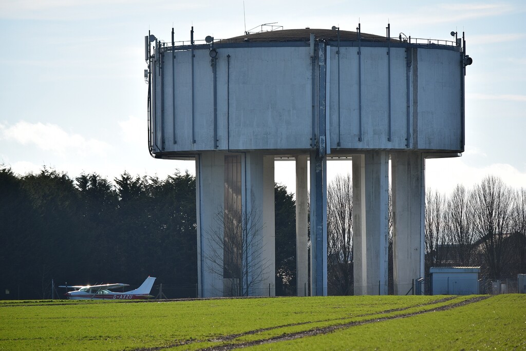 A water tower and an airplane by dragey74