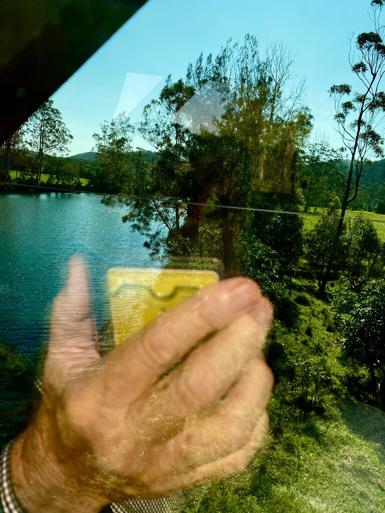 View from train window blocked by selfie of my hand.  by johnfalconer