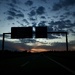 Sunset under the road sign