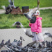 A girl in a pink jacket and doves